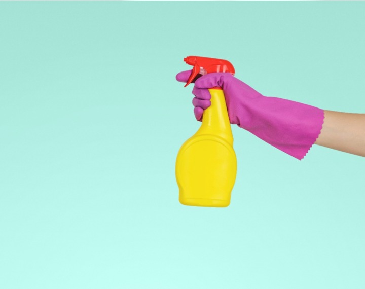 Cleaning bottle held by gloved hand