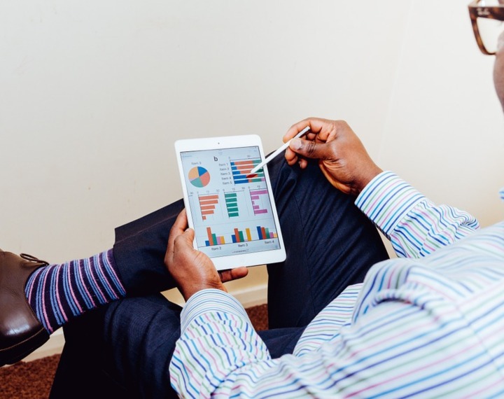 Man using tablet to view graphs and charts