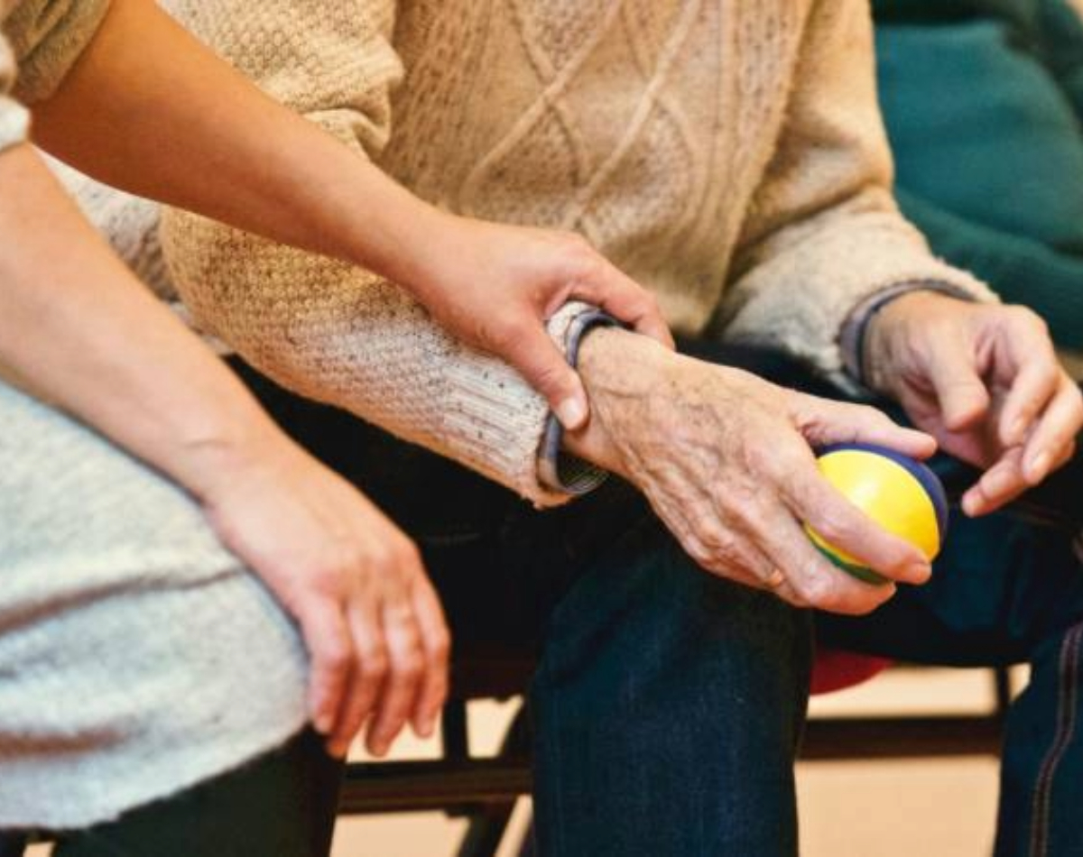 Elderly man holding ball