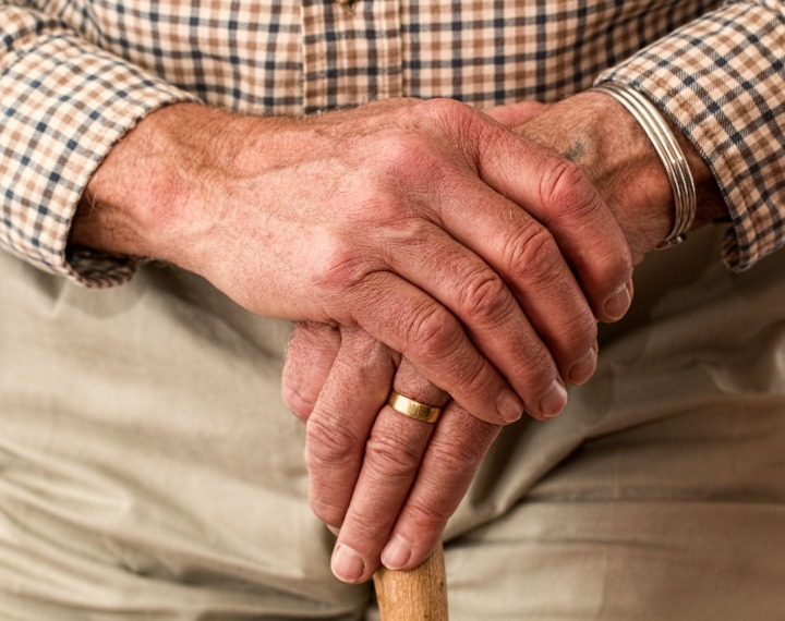 Serniors' hands on walking stick