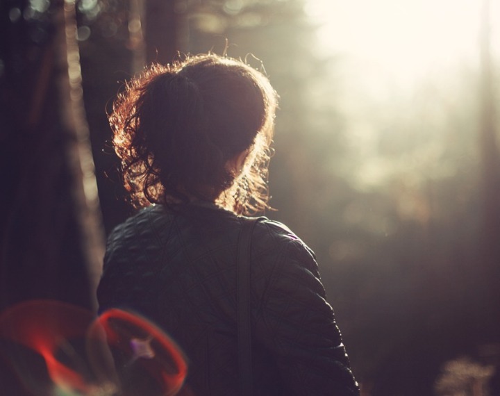 Person in woods with sun glowing