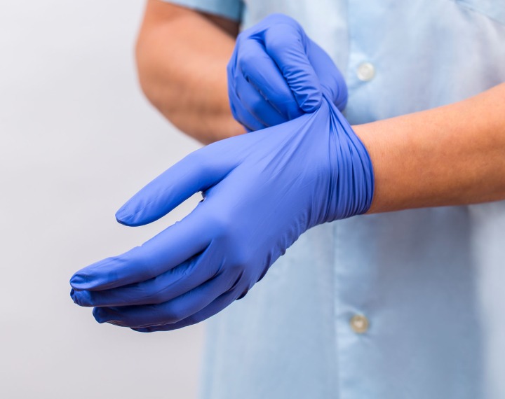 Dry Cleaners Employee Hands In Rubber Protective Gloves Removing