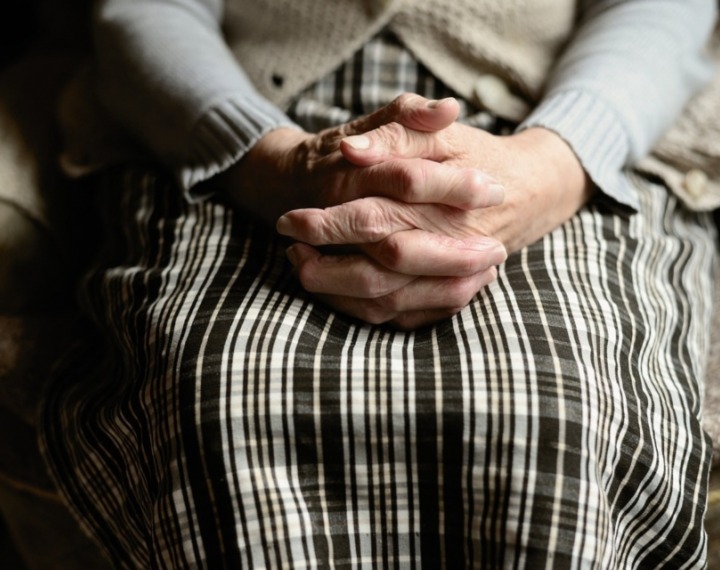 Senior woman with hands clasped in lap